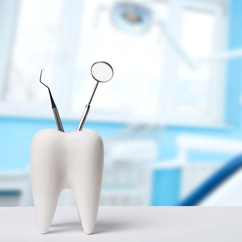 Zahn mit Zahnarztinstrumenten